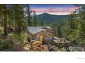 Charming mountain home with a spacious deck and stunning views of the surrounding forest and mountain range at 398 Fred Rd, Boulder, CO 80302