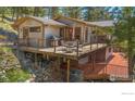 Modern home with a large wooden deck for outdoor dining and enjoying the surrounding mountain views at 398 Fred Rd, Boulder, CO 80302