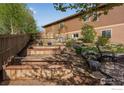 Multi-tiered landscaped backyard featuring raised garden beds, stone accents, and a chair at 4000 Donnington Cir, Castle Rock, CO 80104