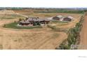 Aerial view of estate, showcasing the custom home, shop buildings, and vast acreage in a serene country setting at 5454 County Road 38, Platteville, CO 80651