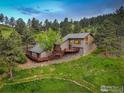 Aerial view of a beautiful home with a spacious deck surrounded by lush greenery at 8664 Middle Fork Rd, Boulder, CO 80302