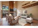 Bright living room with stone fireplace, wood accents and sliding glass doors to the outside at 8664 Middle Fork Rd, Boulder, CO 80302