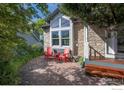 Cozy outdoor patio with stone facade and two red Adirondack chairs, perfect for relaxation at 902 Grove Dr, Louisville, CO 80027