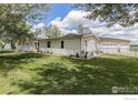 Lovely home with a well-manicured lawn, detached garage, and a fenced yard at 10635 County Road 24, Fort Lupton, CO 80621