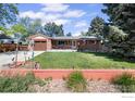 Charming brick home featuring an inviting front porch and well-manicured lawn at 1234 S Holland Ct, Lakewood, CO 80232