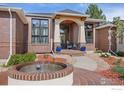 Charming brick home featuring a lovely fountain, decorative columns, and well-maintained landscaping at 13 Blue Heron Dr, Thornton, CO 80241