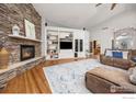 Spacious living room with stone fireplace, built-in shelving, and hardwood floors, creating a cozy atmosphere at 13 Blue Heron Dr, Thornton, CO 80241