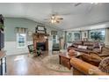 Cozy living room featuring a stone fireplace, hardwood floors, and large windows providing lots of natural light at 1428 S County Road 23E, Berthoud, CO 80513