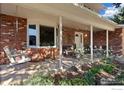 Welcoming covered front porch with brick accents, comfortable seating, and decorative plants at 1513 Elmhurst Dr, Longmont, CO 80503