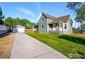 View of a two-story home with a detached garage and long driveway, all set in a grassy yard at 1711 Antero Dr, Longmont, CO 80504