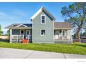 A two-story home featuring freshly painted siding, bright white trim, and a cozy front porch at 1711 Antero Dr, Longmont, CO 80504