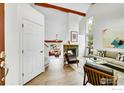 Bright living room with a fireplace, wood beams, hardwood floors, and ample natural light at 2335 Dogwood Cir, Louisville, CO 80027