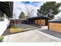 Spacious backyard featuring a covered carport, a grassy area, and well-maintained landscaping at 2435 S Meade St, Denver, CO 80219