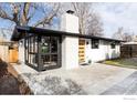 Contemporary home showcasing a sleek exterior design, updated with black framed windows and modern door at 2435 S Meade St, Denver, CO 80219