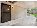 Covered condo entrance with secure door, concrete patio, and view of landscaping at 2525 S Dayton S Way # 2301, Denver, CO 80231