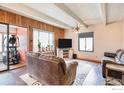Cozy living room featuring hardwood floors, beamed ceiling, large window and comfortable furnishings at 2525 S Dayton S Way # 2301, Denver, CO 80231