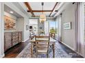 Elegant dining room with a rustic table, wood beams, and large windows with picturesque mountain views at 290 Skyhill Dr, Evergreen, CO 80439