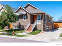 View of a charming brown two-story home with a well-manicured front lawn and driveway at 3341 Yukon Ct, Wheat Ridge, CO 80033