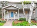 Inviting front porch with white railings, a cozy seating area, and a blue front door at 4157 19Th St, Boulder, CO 80304