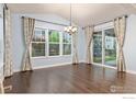 Inviting dining area with vaulted ceiling, large windows, stylish chandelier, and sliding glass doors at 4631 Lakeside Dr, Firestone, CO 80504