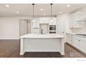 Stunning kitchen with a spacious island, hardwood floors, stainless steel appliances, and ample cabinet space at 4631 Lakeside Dr, Firestone, CO 80504