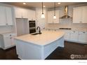 Bright kitchen with white cabinets, stainless appliances and a large center island at 4631 Lakeside Dr, Firestone, CO 80504