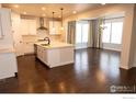 Spacious kitchen with white cabinets, stainless appliances and hardwood floors at 4631 Lakeside Dr, Firestone, CO 80504