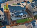 Aerial view of the home's backyard, with patio, fenced yard, play area, and landscaping at 515 Orion Ave, Erie, CO 80516