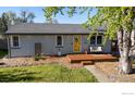 Charming home featuring a bright yellow front door, a cozy bench, and a well-maintained lawn at 6260 W 61St Ave, Arvada, CO 80003