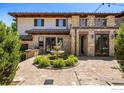 Charming courtyard with a stone fountain, brick pavers, and lush landscaping at 6851 Goldbranch Dr, Niwot, CO 80503