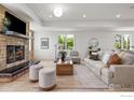 Cozy living room featuring a stone fireplace, plush seating, and abundant natural light at 6851 Goldbranch Dr, Niwot, CO 80503