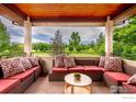 Balcony with comfortable lounge seating and decorative pillows overlooking well-manicured backyard at 7205 Rustic Trl, Boulder, CO 80301