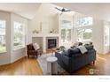 Open-concept living room with vaulted ceilings, lots of natural light, fireplace, and hardwood floors at 805 Summer Hawk Dr # 100, Longmont, CO 80504