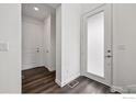 Bright foyer with dark hardwood flooring, white walls, and a glass-paneled front door, creating a modern entrance at 926 Hearteye Trl, Lafayette, CO 80026