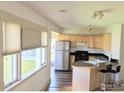 Bright kitchen featuring stainless steel appliances, light wood cabinets, and a breakfast bar with seating at 936 Parkview St, Louisville, CO 80027
