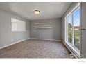 Bright living room features neutral carpet and paint, with a large window at 1043 Lilac Ct, Broomfield, CO 80020