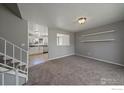 Bright living room features neutral carpet and paint, plus access to updated kitchen at 1043 Lilac Ct, Broomfield, CO 80020