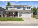 Charming two-story home features a well-manicured lawn and an attached two-car garage at 14049 Detroit Dr, Thornton, CO 80602
