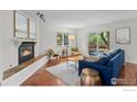 Sun-filled living room with hardwood floors, a cozy fireplace, and access to the backyard, ideal for entertaining at 1409 Quince Ave, Boulder, CO 80304
