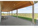 Inviting covered patio with a wood ceiling and peaceful views of the surrounding landscape at 14407 County Road 18 1/2 Rd, Fort Lupton, CO 80621