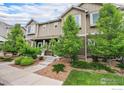 Attractive townhome with a well-manicured lawn, stone accents, and a cozy front entrance at 14700 E 104Th Ave, Commerce City, CO 80022