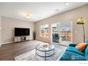 Well-lit living room featuring hardwood floors, sliding glass doors, and a contemporary design at 14700 E 104Th Ave, Commerce City, CO 80022