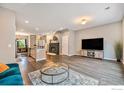 Open-concept living room featuring hardwood floors, a modern fireplace, and a spacious layout at 14700 E 104Th Ave, Commerce City, CO 80022