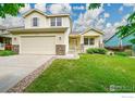 Charming two-story home with a well-maintained lawn and inviting front porch at 1824 Ute Creek Dr, Longmont, CO 80504
