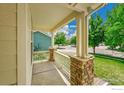 Covered front porch with sturdy columns and white railing at 1824 Ute Creek Dr, Longmont, CO 80504