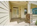 Welcoming front porch with stone accents and a decorative wreath on the front door at 1824 Ute Creek Dr, Longmont, CO 80504