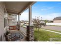 Inviting covered front porch features a porch swing and a view of the neighborhood at 2200 Cadman St, Berthoud, CO 80513