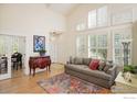 Open-concept living room with hardwood floors, tall ceilings, and plenty of natural light at 2758 Meadow Mountain Trl, Lafayette, CO 80026