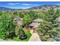 Aerial view of a home nestled among lush greenery, showcasing mountain views and a well-maintained lawn at 3345 15Th St, Boulder, CO 80304