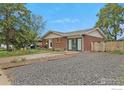 Well-maintained brick exterior with ample parking, attractive landscaping, and mature trees at 437 Fox St, Longmont, CO 80504